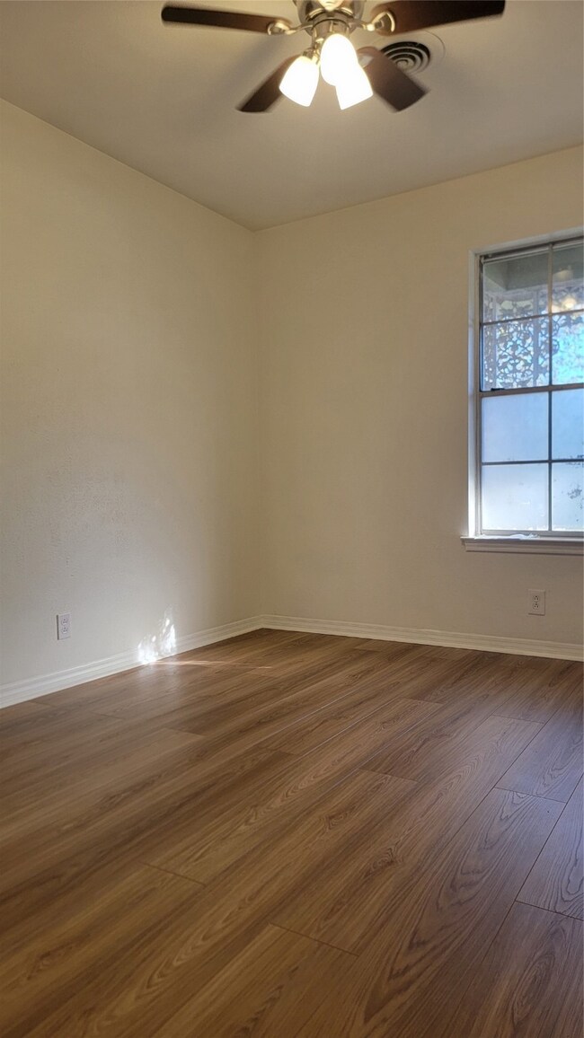 Unfurnished room with ceiling fan and dark hardwood / wood-style flooring