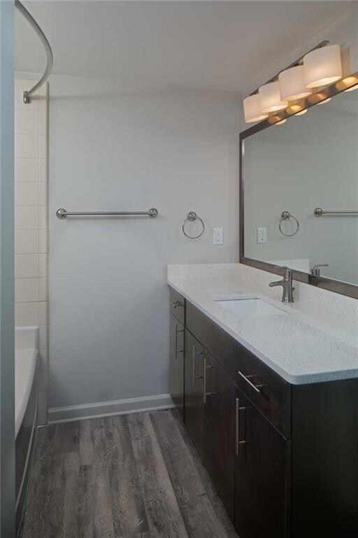 Bathroom featuring tiled shower / bath, vanity, an