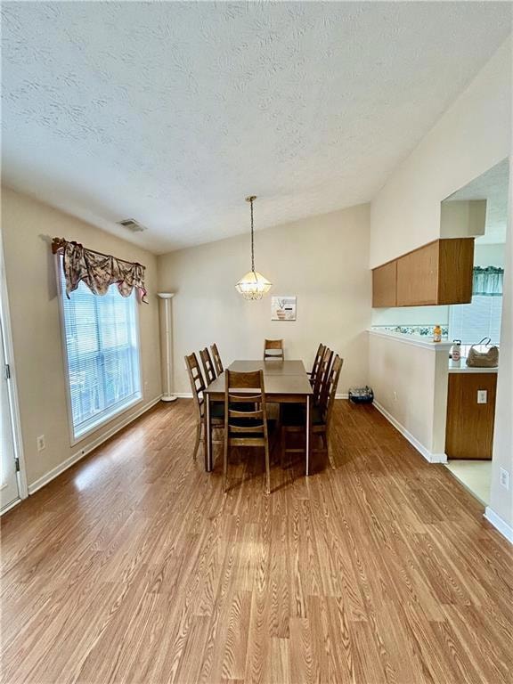 Dining area with light wood-style floors, a textur