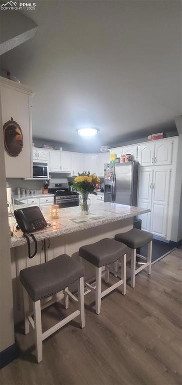 Kitchen with range, a breakfast bar area, laminate