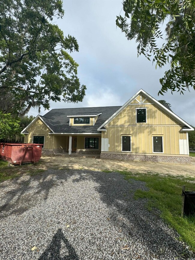 View of front of property with roof with shingles and board and batten siding