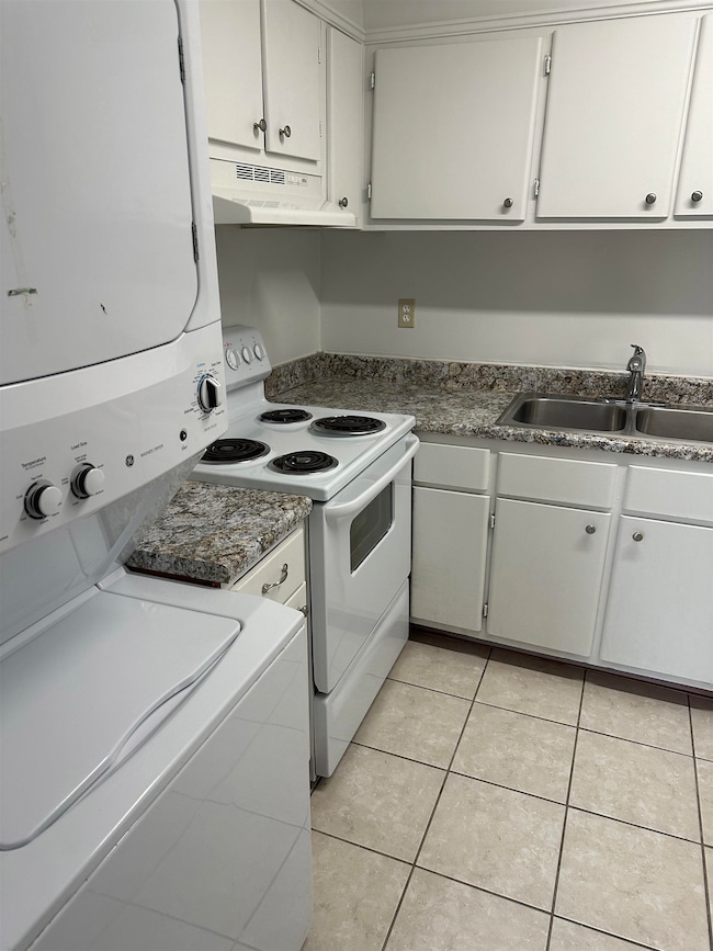 Kitchen with under cabinet range hood, a sink, sta