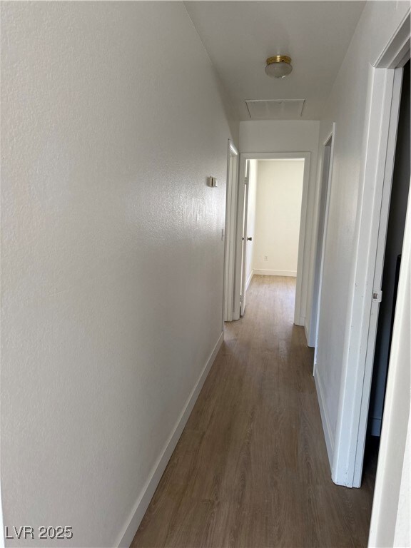Hall with wood finished floors and attic access