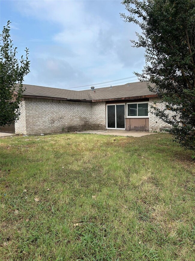 Rear view of house featuring a lawn