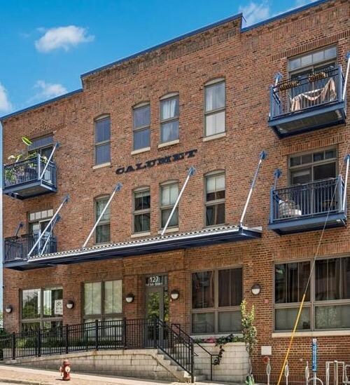 Historic Calumet Lofts building with rich architectural details including gorgeous exposed brick, heavy timber framing, contemporary industrial touches, and great community amenities..