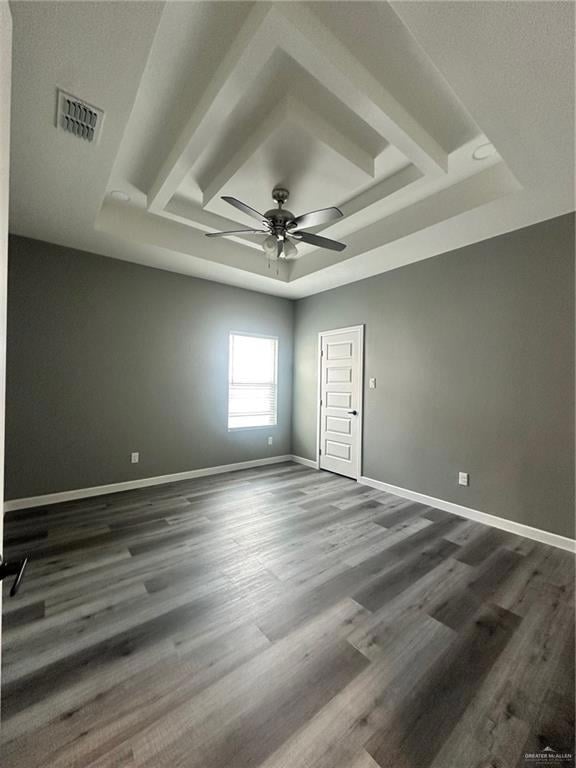 Spare room featuring a tray ceiling, and ceiling fan