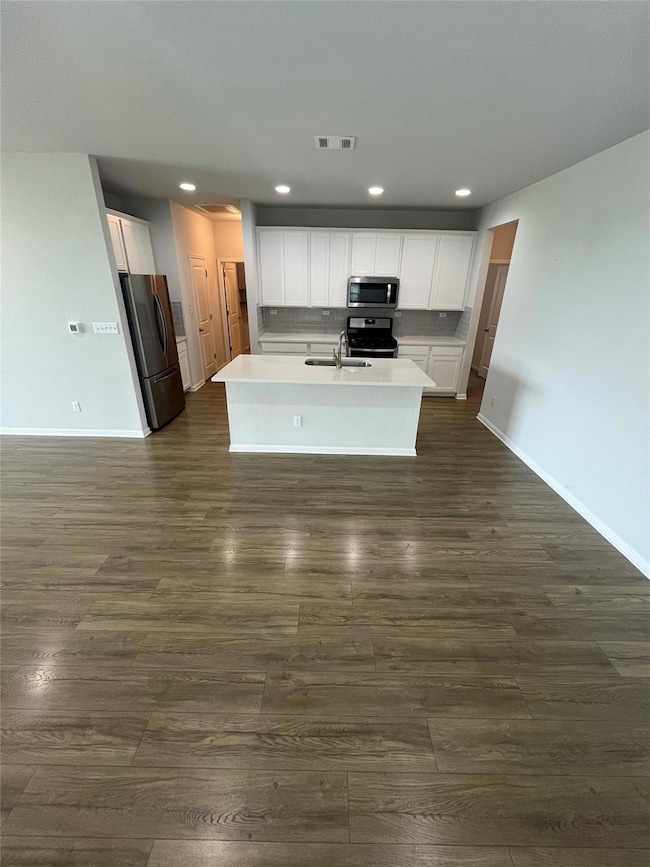 Kitchen with dark wood finished floors, appliance