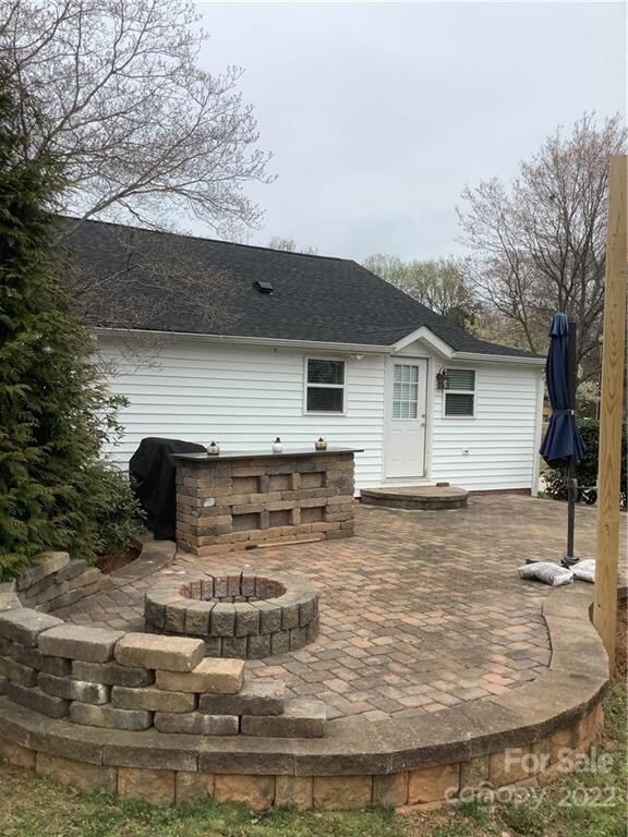 Ready to entertain on custom back patio with fire pit, bar, and polls for tenting/shape