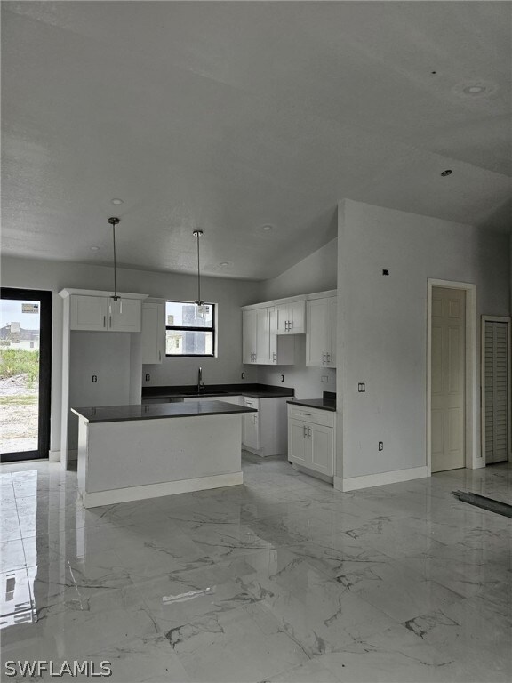 Kitchen featuring white cabinetry, sink, a center