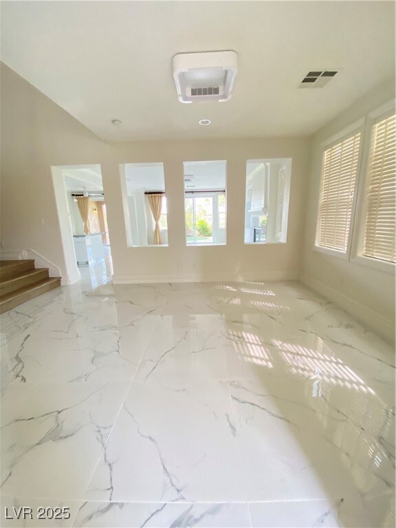 Unfurnished living room with marble finish floor,