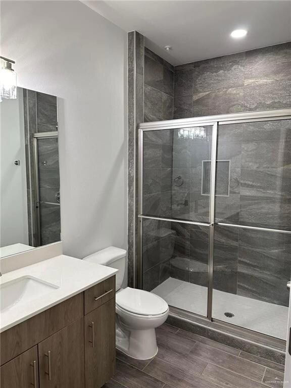 Bathroom with vanity, toilet, and walk in shower