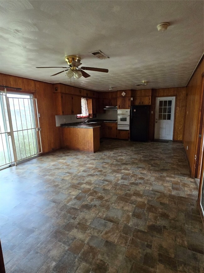 Spacious kitchen with wood-paneled walls, ceiling