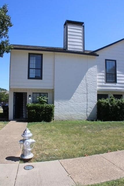 View of front facade with a chimney and a front la