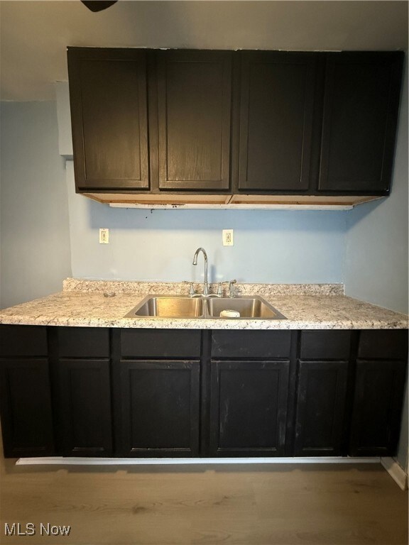 Kitchen featuring dark cabinets and a sink