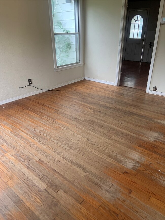 Spare room with original hardwood flooring and baseboards