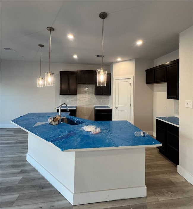Kitchen with backsplash, wood finished floors, a s