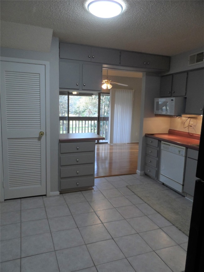The kitchen with gray cabinets, tiled flooring, an