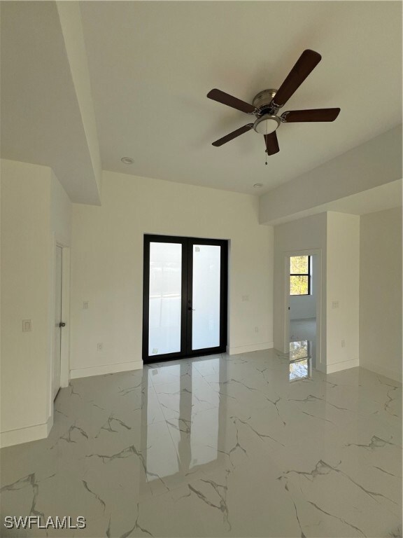 Spare room with marble finish floor, baseboards, a