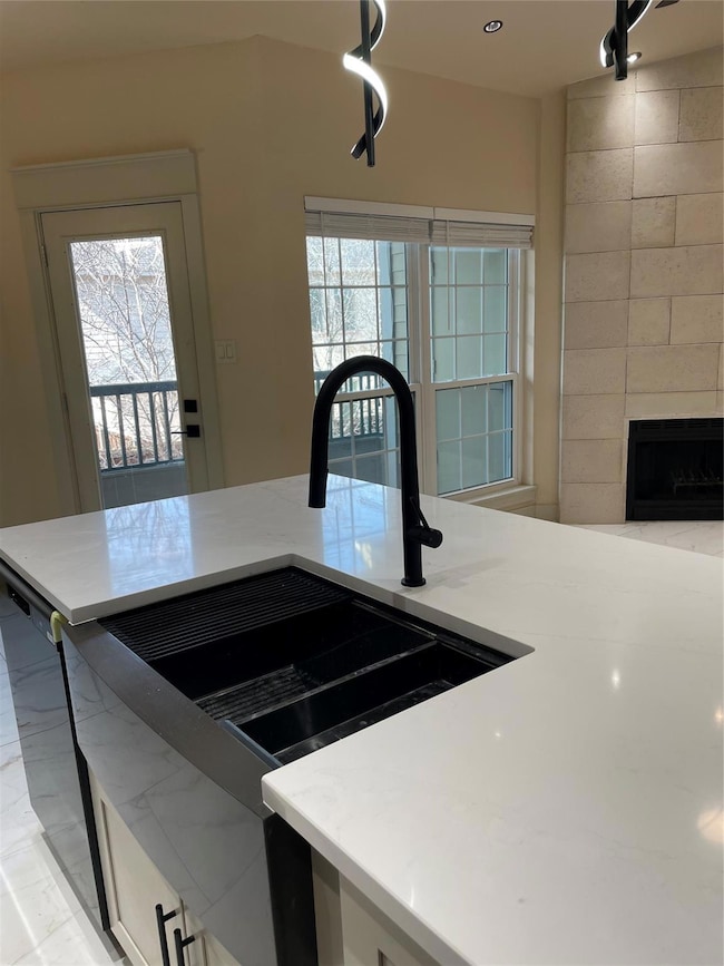 Kitchen with a fireplace, light stone countertops,
