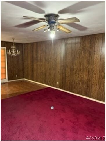 Carpet, wood panel walls, ceiling fan.