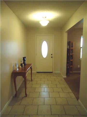 Tiled foyer leads directly to living room with a formal dining room on the left.