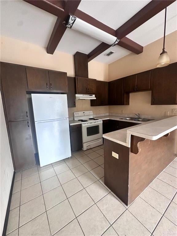 Kitchen with white appliances, under cabinet range hood, beamed ceiling, light countertops, and light tile patterned flooring