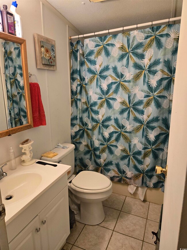 Bathroom featuring vanity, tile patterned floors, a textured ceiling, and a shower with curtain