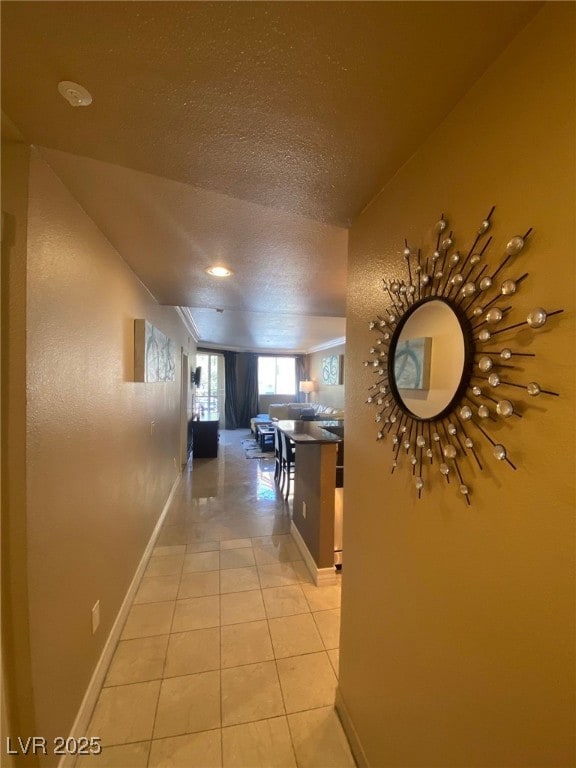 Corridor with light tile patterned flooring, a tex