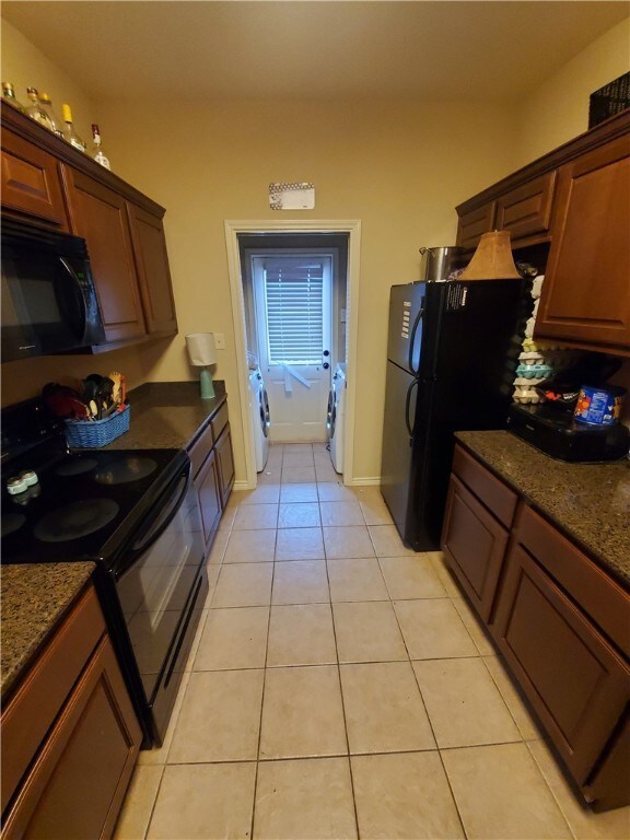 Kitchen featuring black appliances, washer and clo