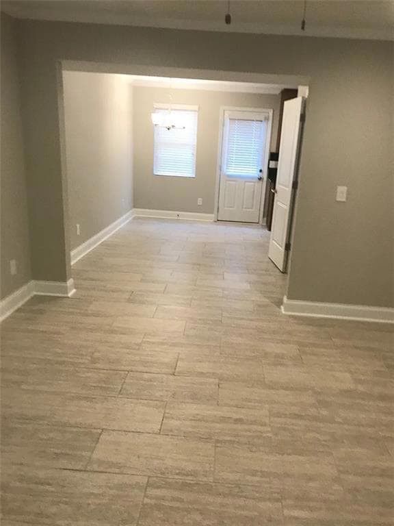 Spare room featuring light wood-type flooring and baseboards