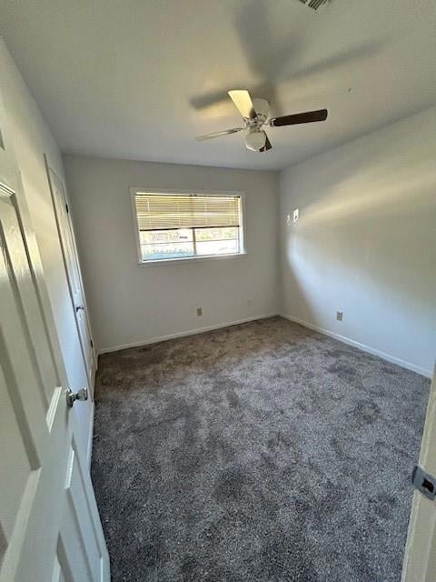 Spare room featuring ceiling fan and dark colored 
