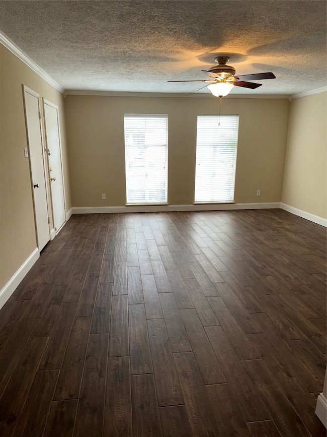 Huge living room with crown molding and wood look tile floor overlooks courtyard and pool