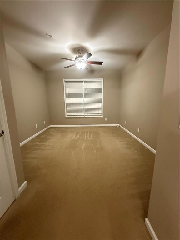 Unfurnished room featuring carpet floors and a ceiling fan
