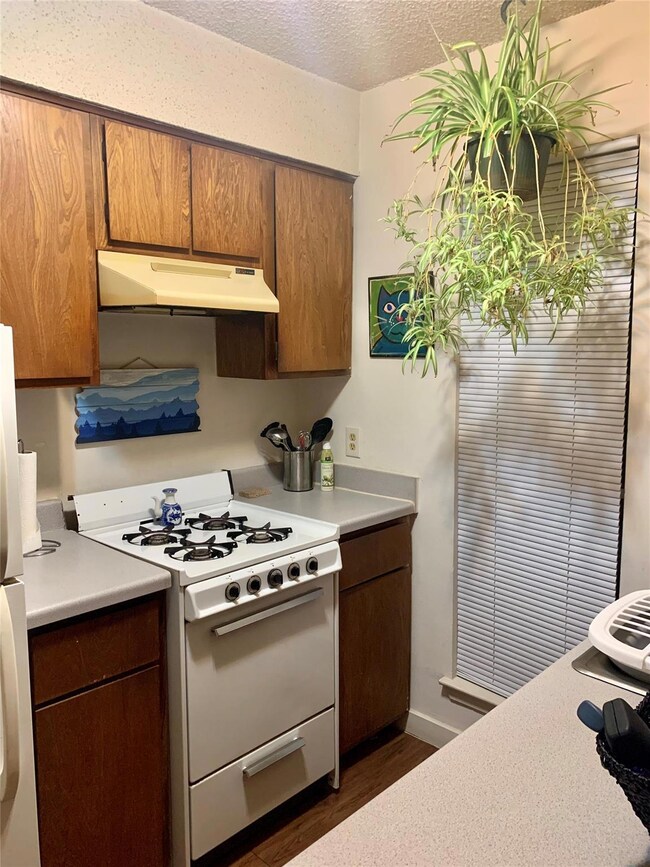 Kitchen featuring under cabinet range hood, white