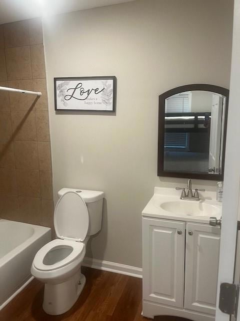 Full bath featuring toilet, wood finished floors, vanity, and baseboards
