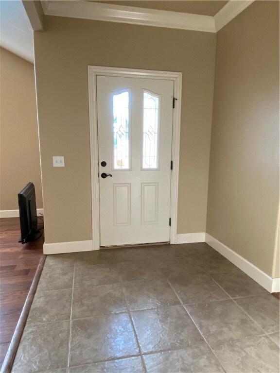 Entryway with crown molding and tile floor.