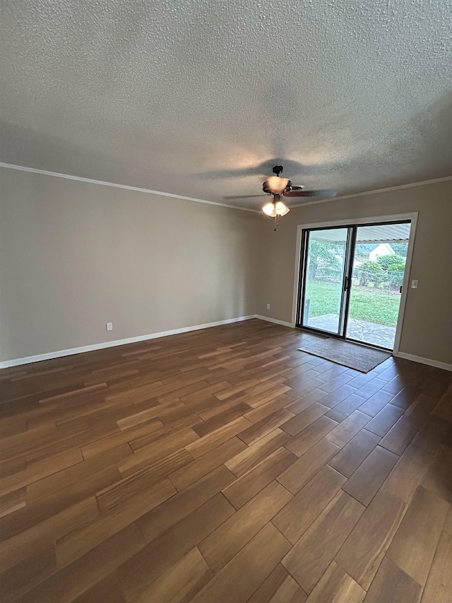 Empty room featuring a textured ceiling, dark wood