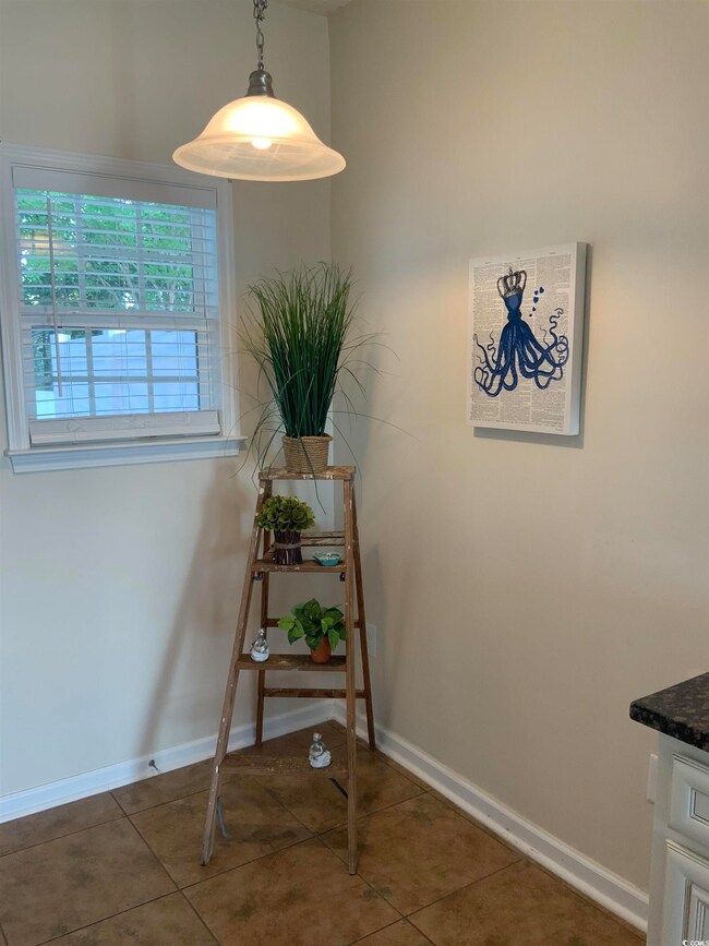 Tiled dining space featuring baseboards