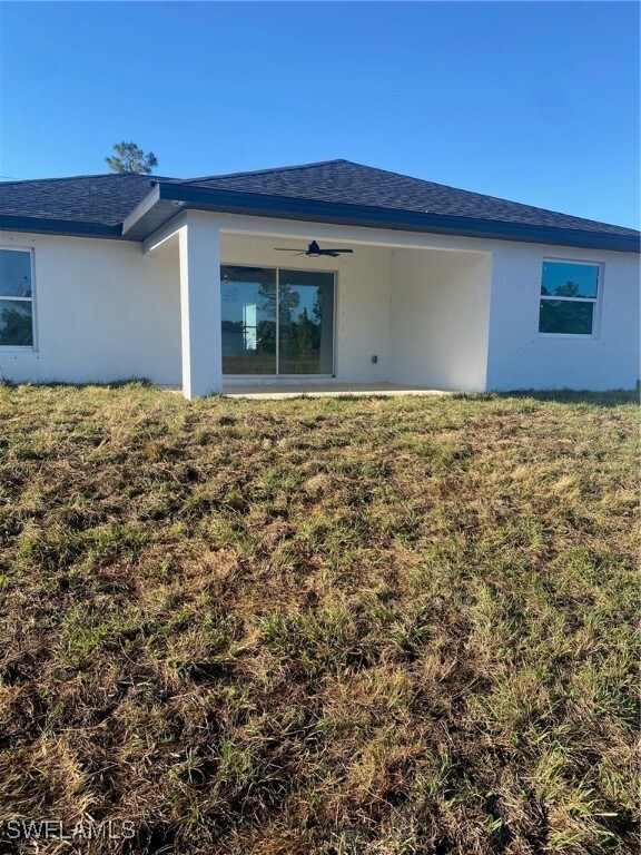 Rear view of property with a yard, roof with shing