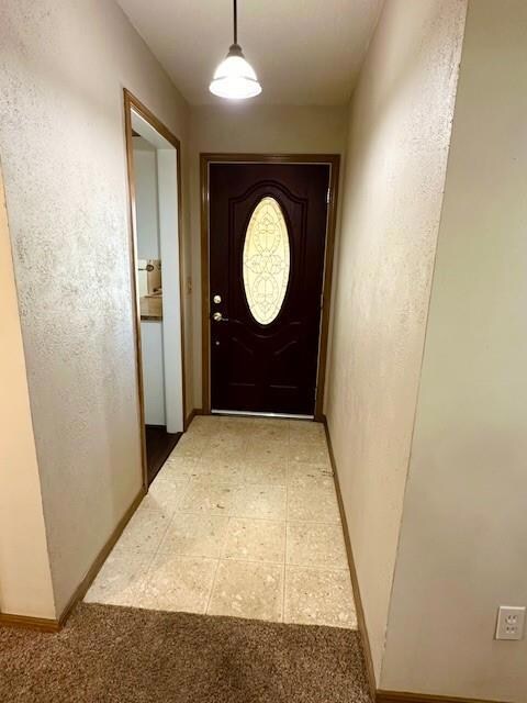 Doorway to outside featuring carpet floors