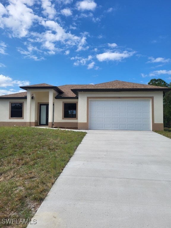 Prairie-style home featuring stucco siding, drivew