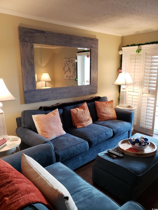 Living room with ornamental molding and a textured