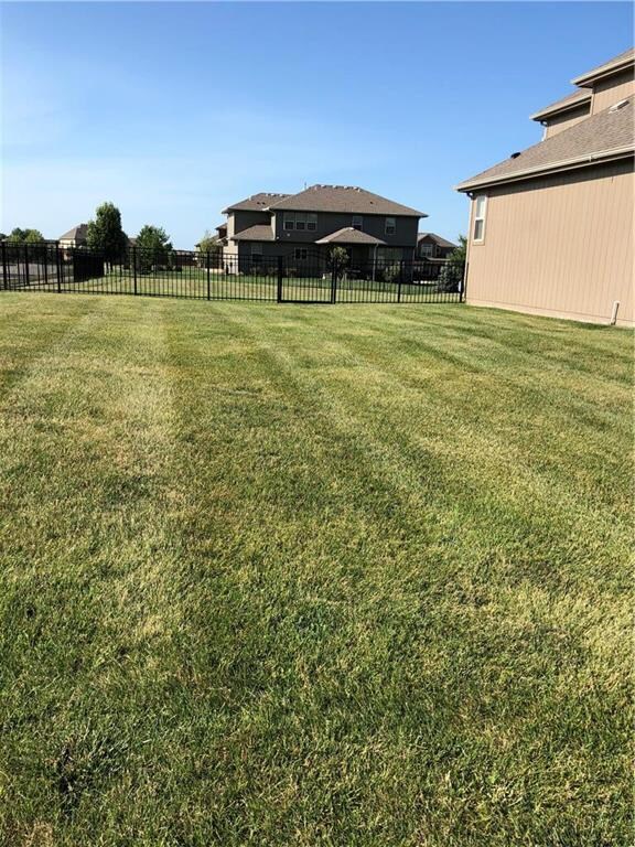 Corner lot well manicured with iron fence