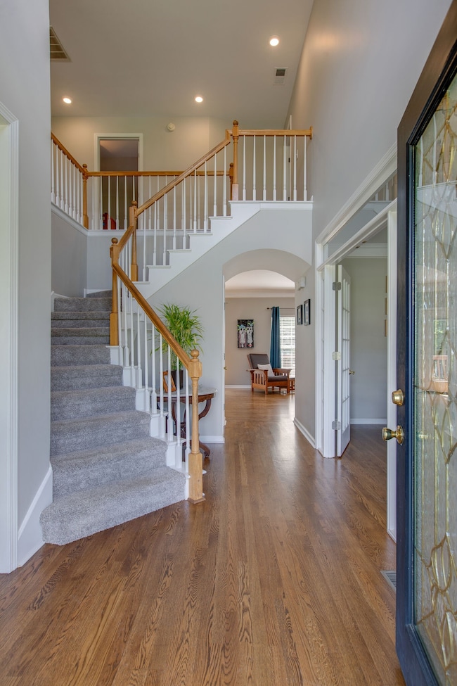The entry foyer features a grand staircase and vaulted ceilings. And check out the gleaming hardwood floors. We will see those throughout the main level.
