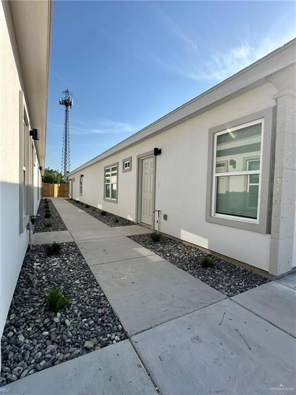 View of exterior entry featuring fence, a patio area, and stucco siding