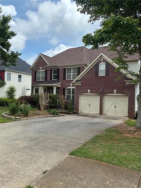 View of front of home featuring driveway, brick siding, a garage, and a shingled roof