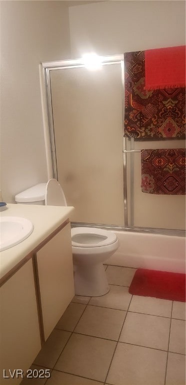 Full bath with vanity, bath / shower combo with glass door, and light tile patterned flooring