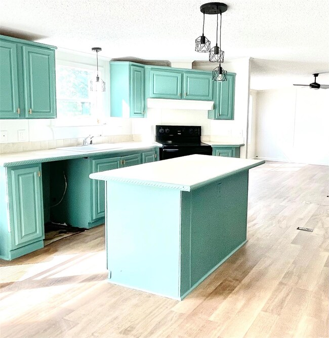 Kitchen featuring green cabinetry, a kitchen islan