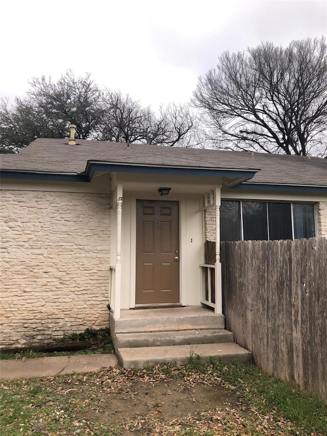 Entrance to property featuring stone siding and a