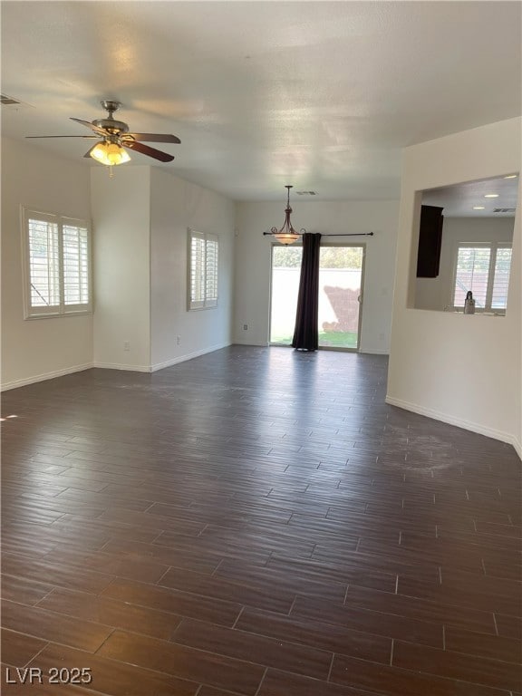 Spare room featuring dark wood-style floors, baseb